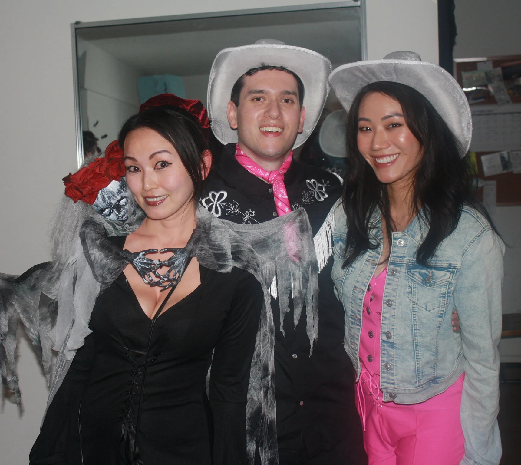 Three friends posing together in hats and costumes